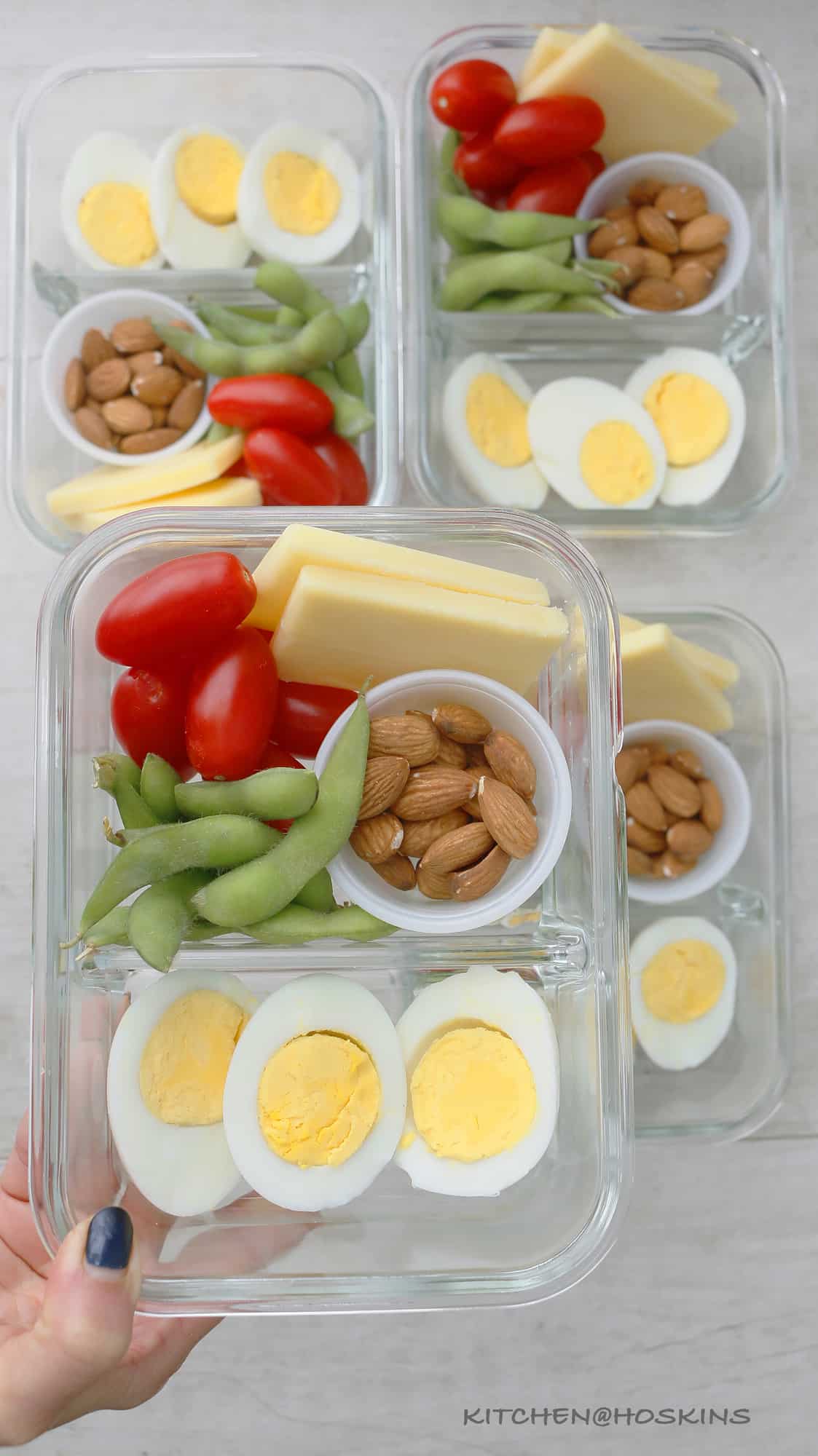 boiled eggs, cheese, almonds, edamame and tomatoes in bento box