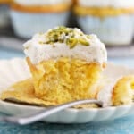 one tres leches cupcake in a white plate. along with a fork.