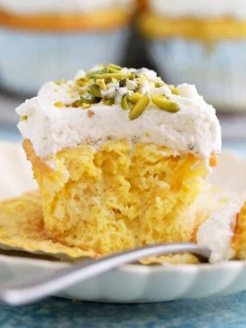 one tres leches cupcake in a white plate. along with a fork.