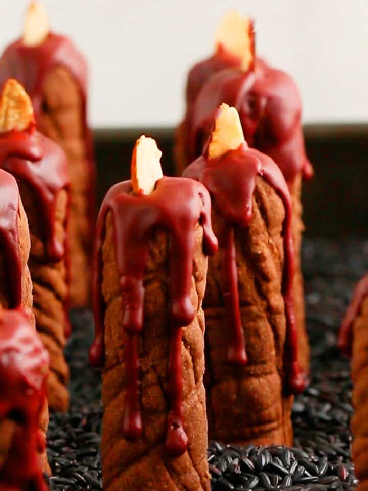 chocolate cookies in the shape of candles placed in a grey tray.