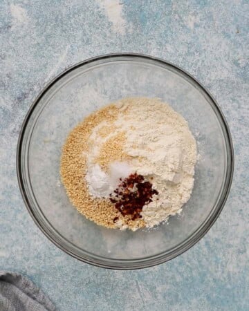 white flour, red pepper and white seeds in a glass bowl.
