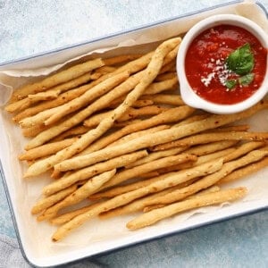 long thin breadsticks in a white tray.