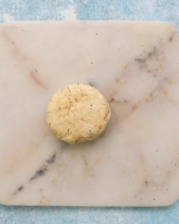 one white dough ball placed on a white marble surface.