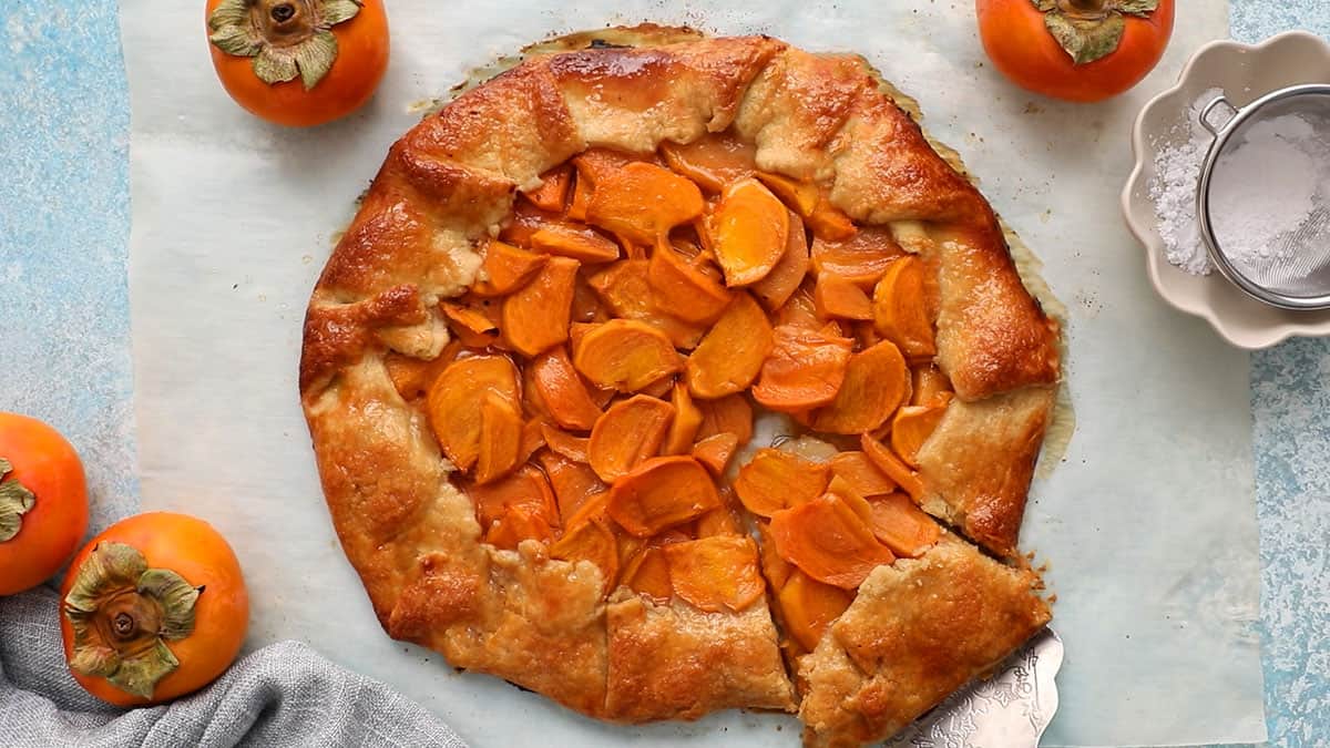 one round persimmon galette on a white parchment paper.