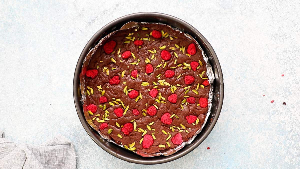 Chocolate fudge mixture set in foil lined a metal spring form pan.