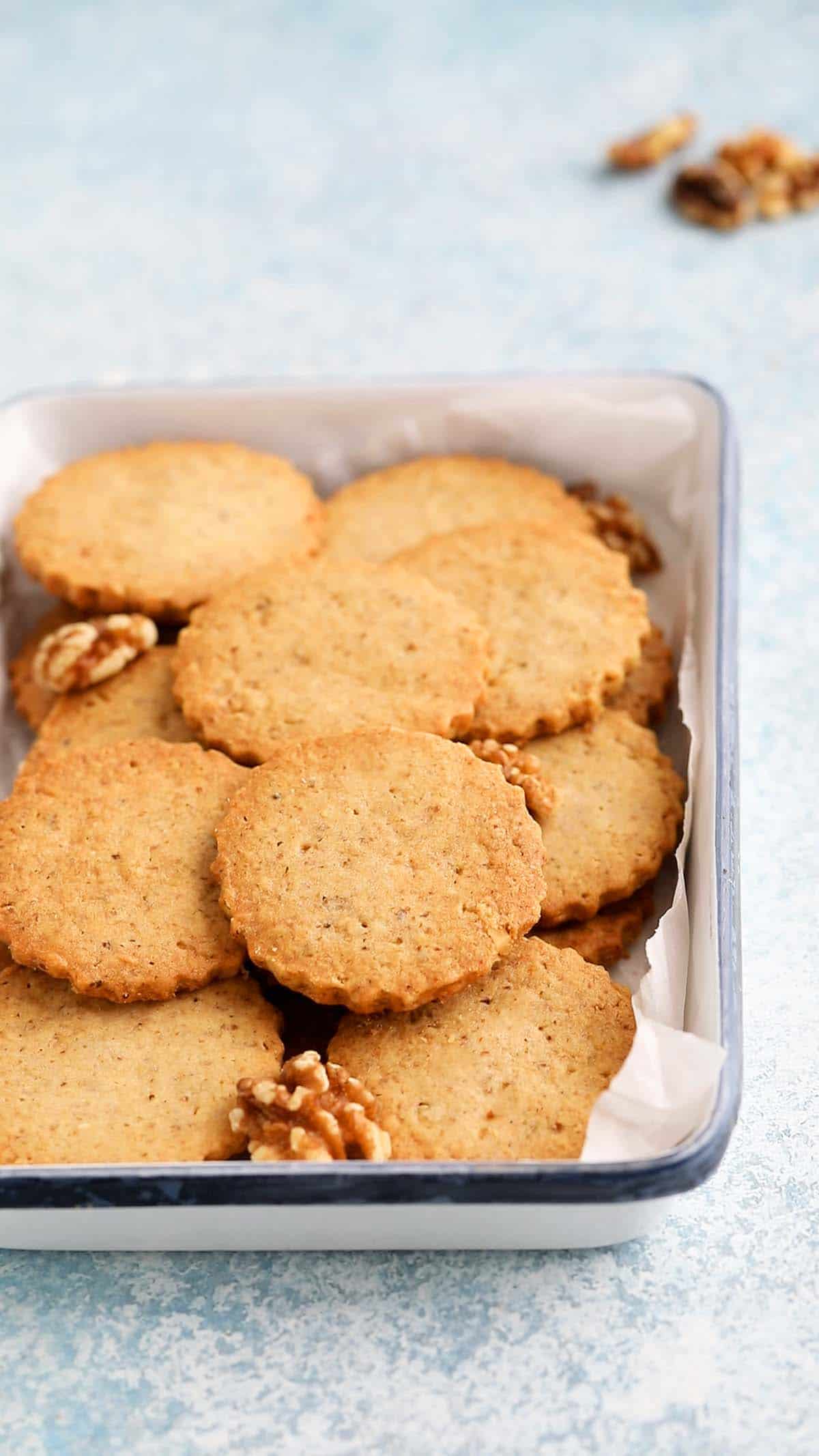 round shaped walnut cookies placed on a white rectangular tray.