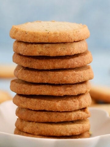 a tall stack of cardamom cookies placed on a white plate.