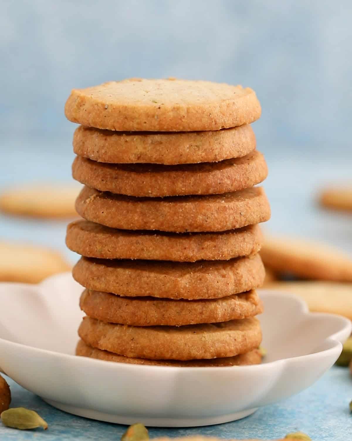 a tall stack of cardamom cookies placed in a fluted tray.