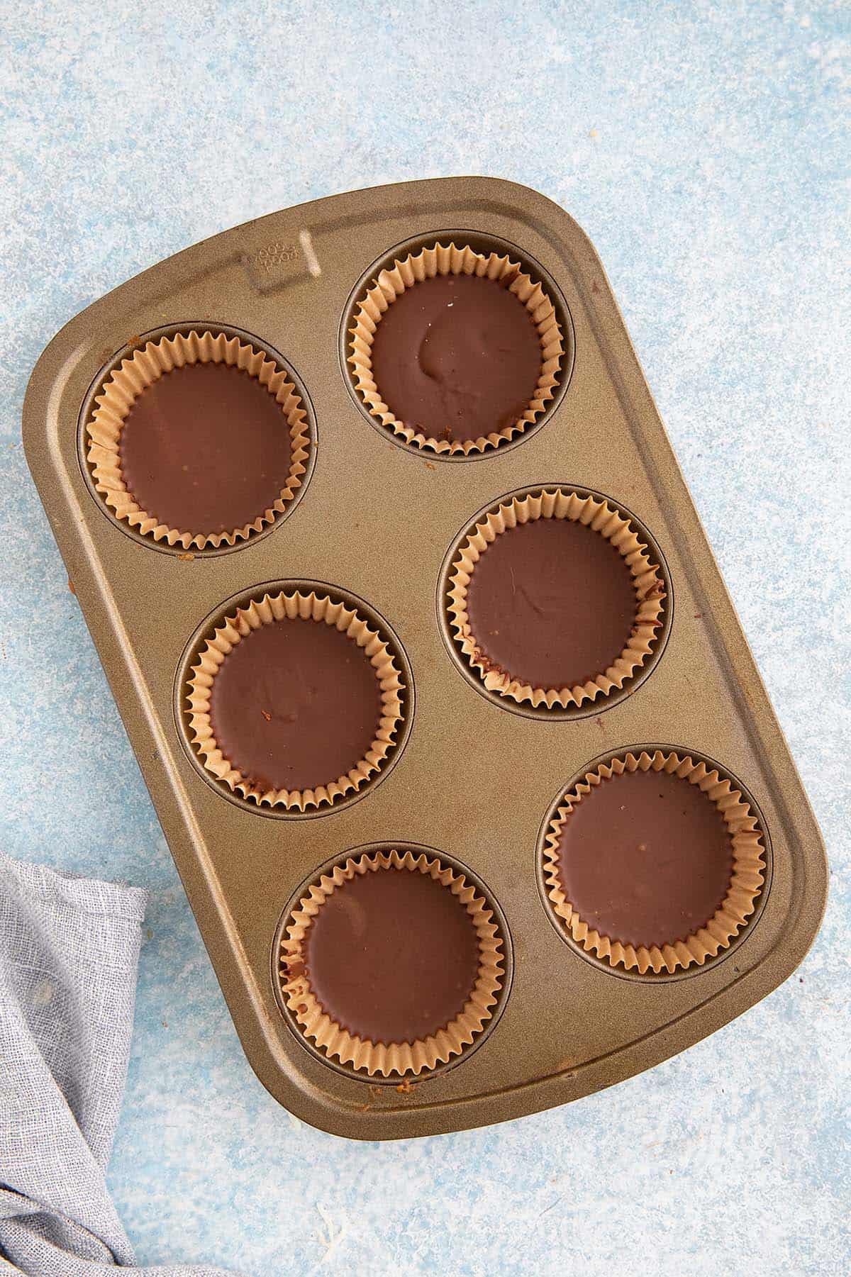 chocolate sunbutter cups in a muffin pan.