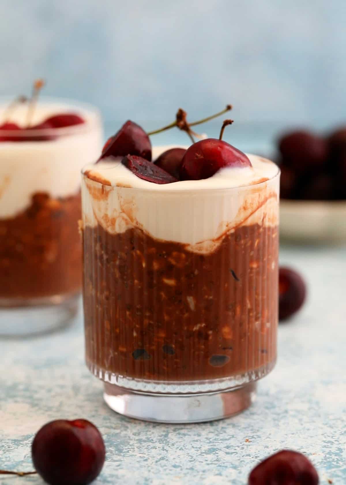 two glass jars with chocolate cherry overnight oats.