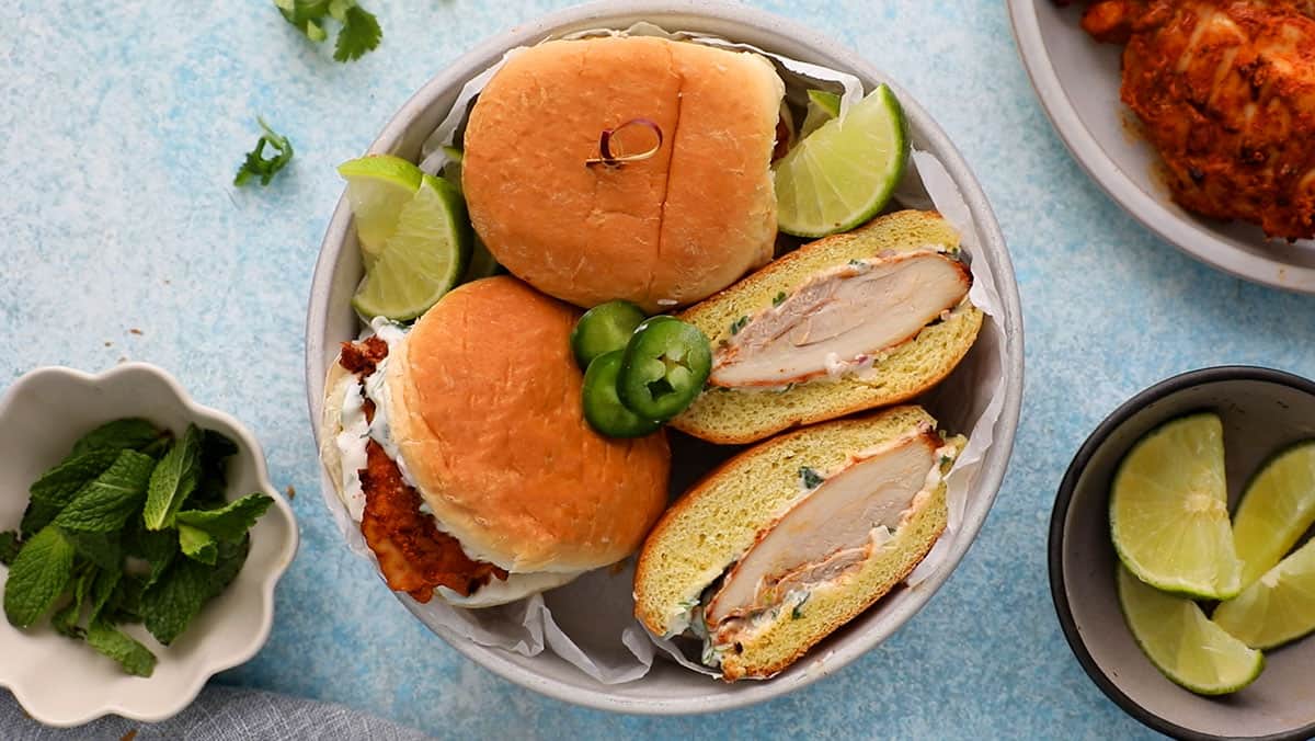 three spicy chicken sandwiches in a white bowl.