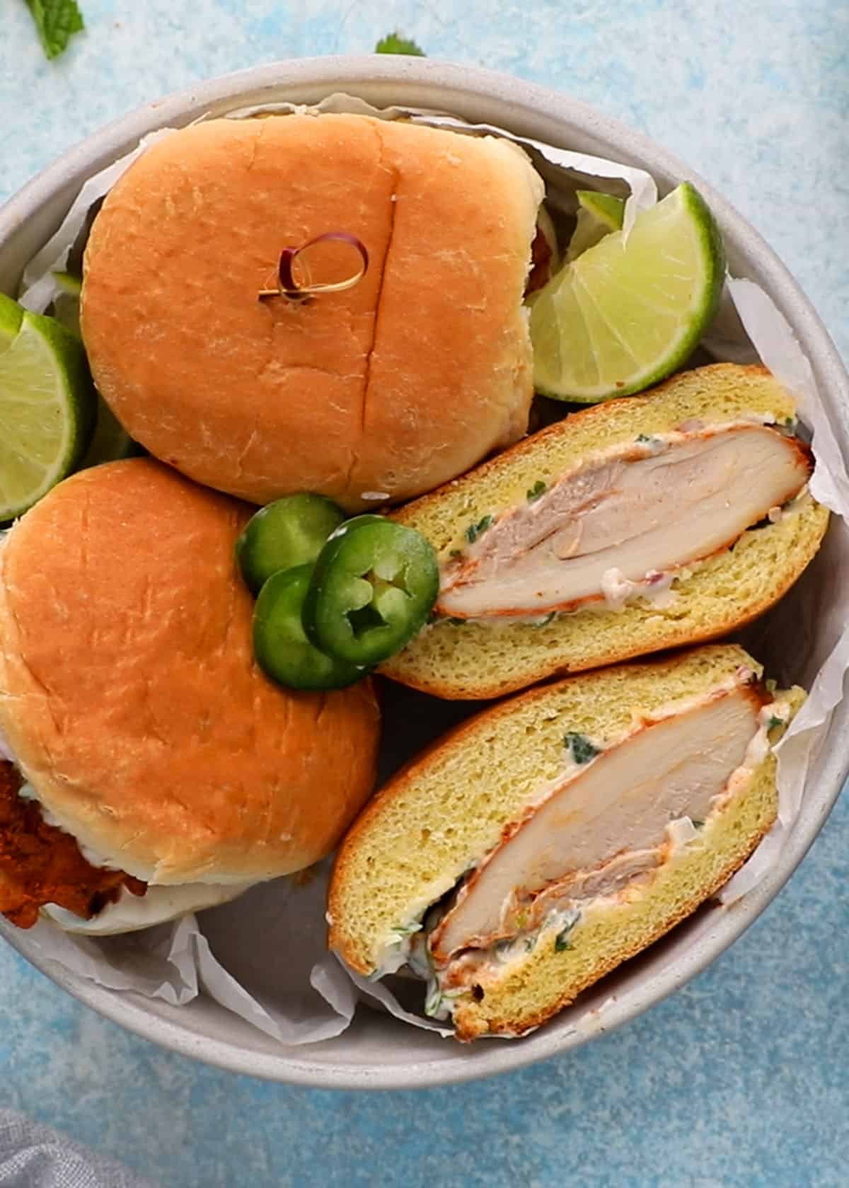three spicy chicken sandwiches in a white bowl.