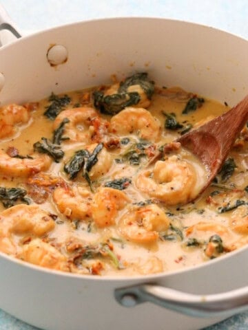 creamy Tuscan shrimp in a white pan.
