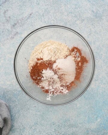 white flour and brown chocolate powder in a glass bowl.