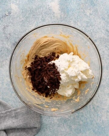 white whipped cream, brown chocolate chips with brown cream in a glass bowl. 