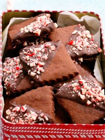 brown chocolate peppermint cookies placed in a red cookie tin.