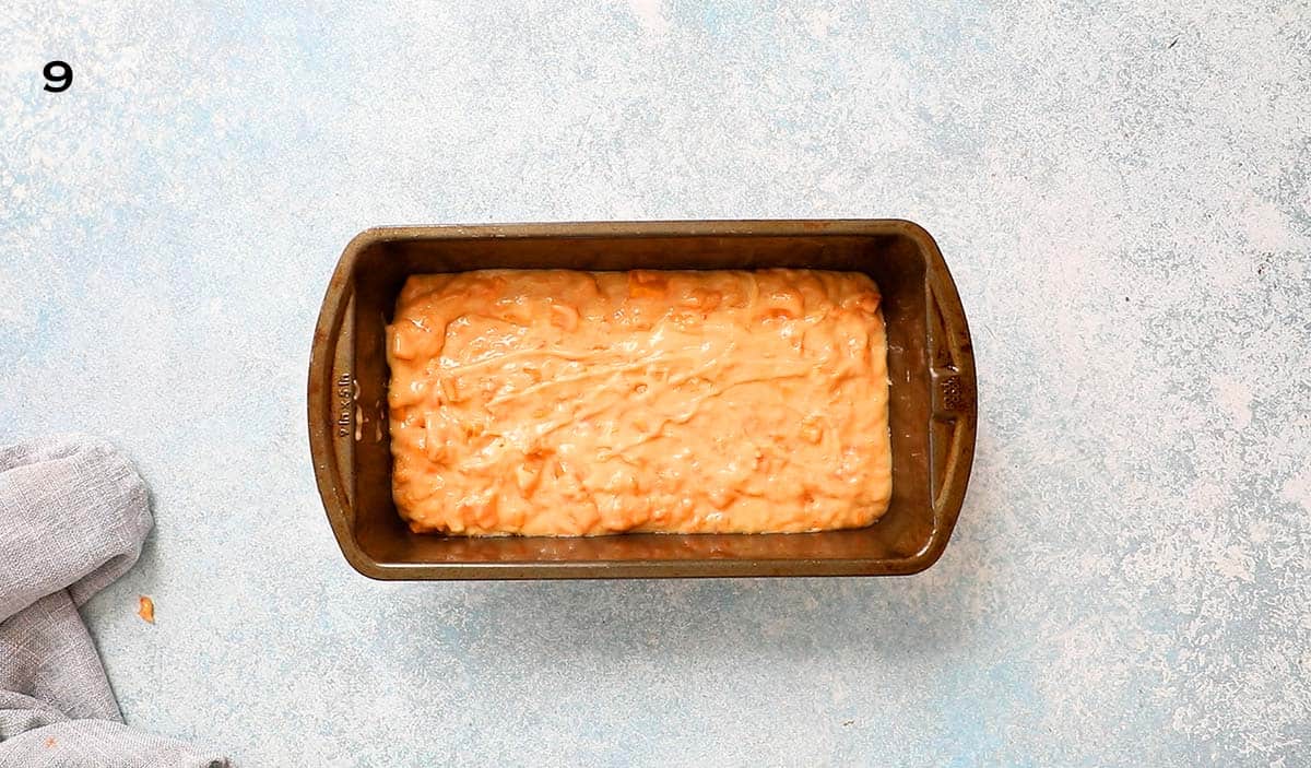 prepared persimmon bread batter in a metal loaf pan.