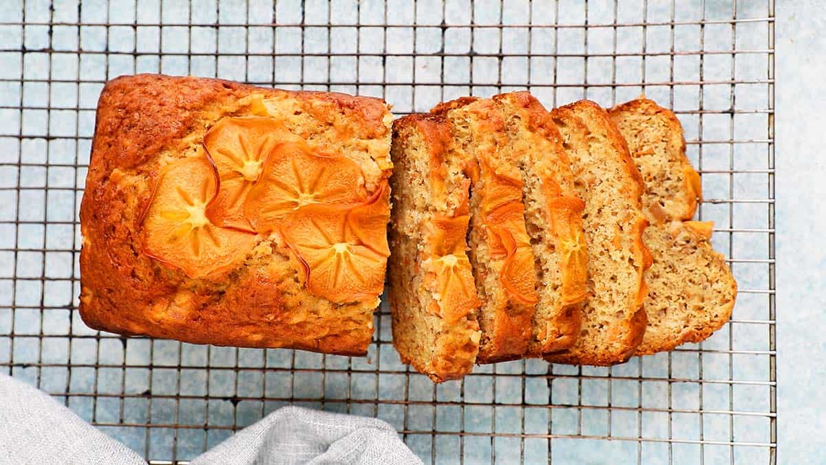 Cut persimmon bread placed on a wire rack.