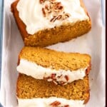 sliced pumpkin cake topped with chopped pecans on a white tray.