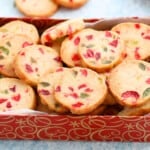 a red cookie box is filled with Christmas cookies.