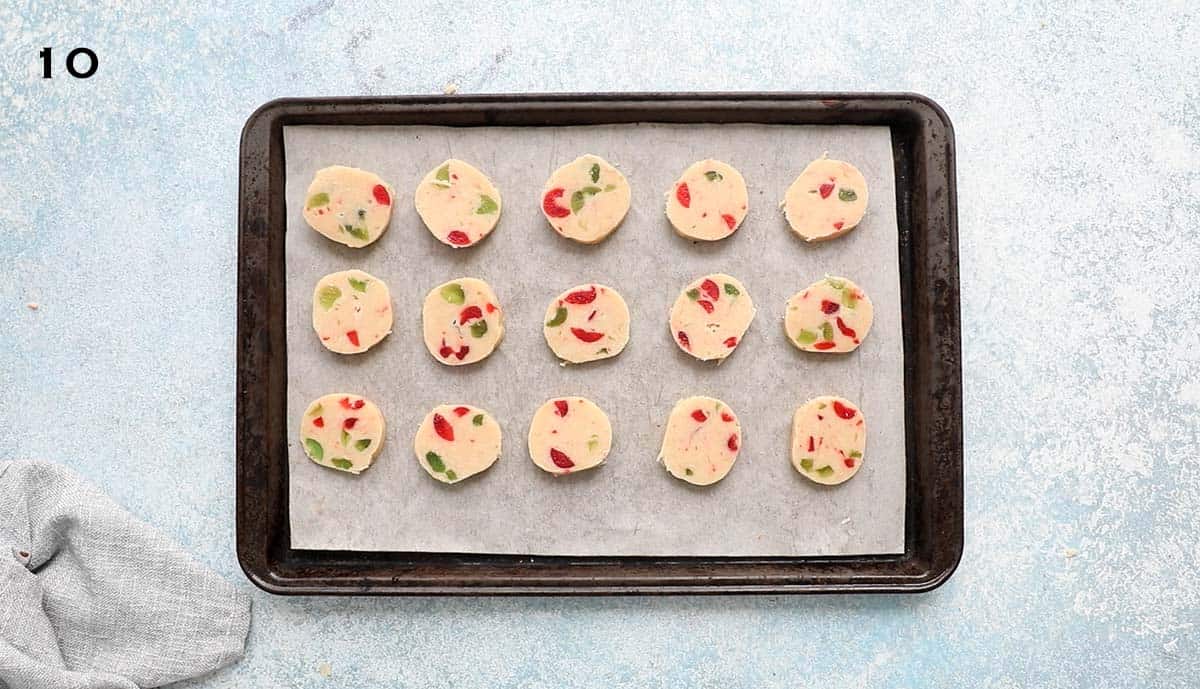 sliced cookie dough placed on a parchment lined baking sheet.