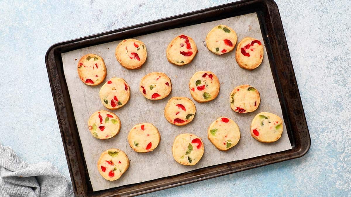 parchment lined baking sheet with baked Christmas cookies.