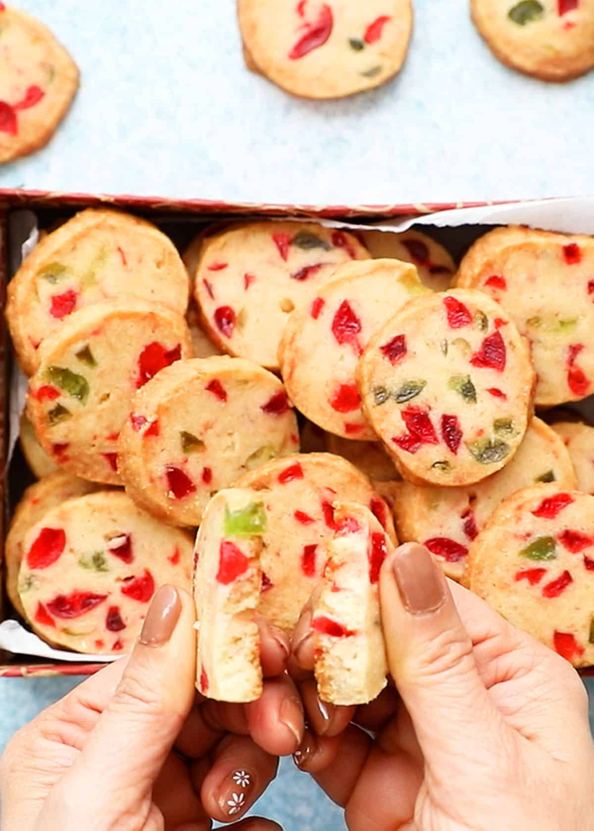 2 hands breaking a cookie into two halves.