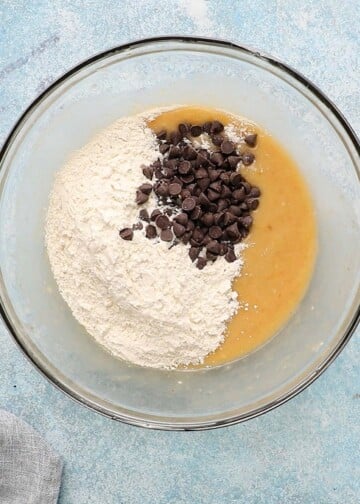 flour, chocolate chips and wet batter in a glass bowl.