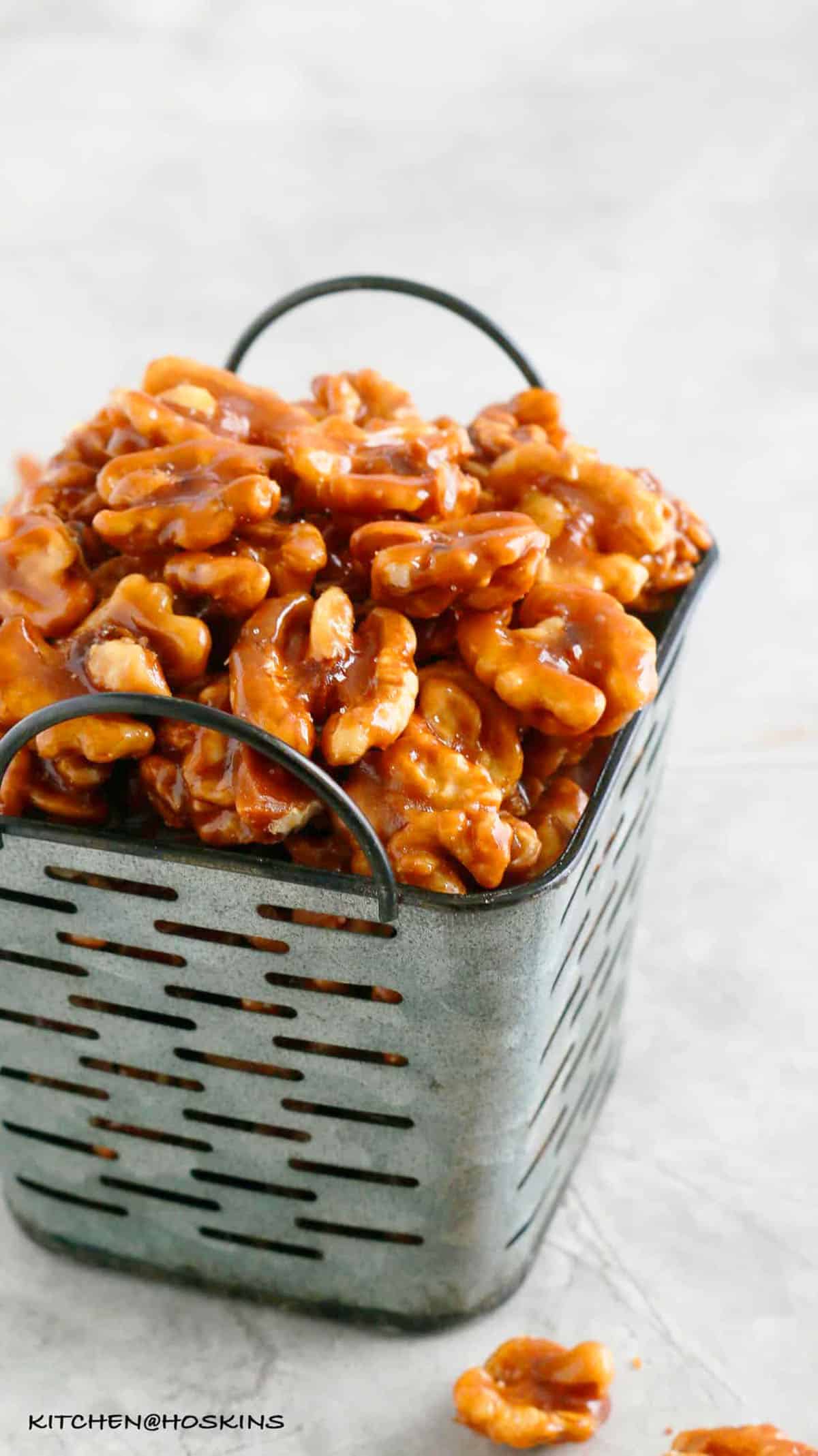 candied walnuts piled high in a grey metal basket.