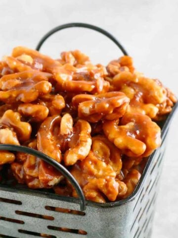 candied walnuts piled high in a grey metal basket.