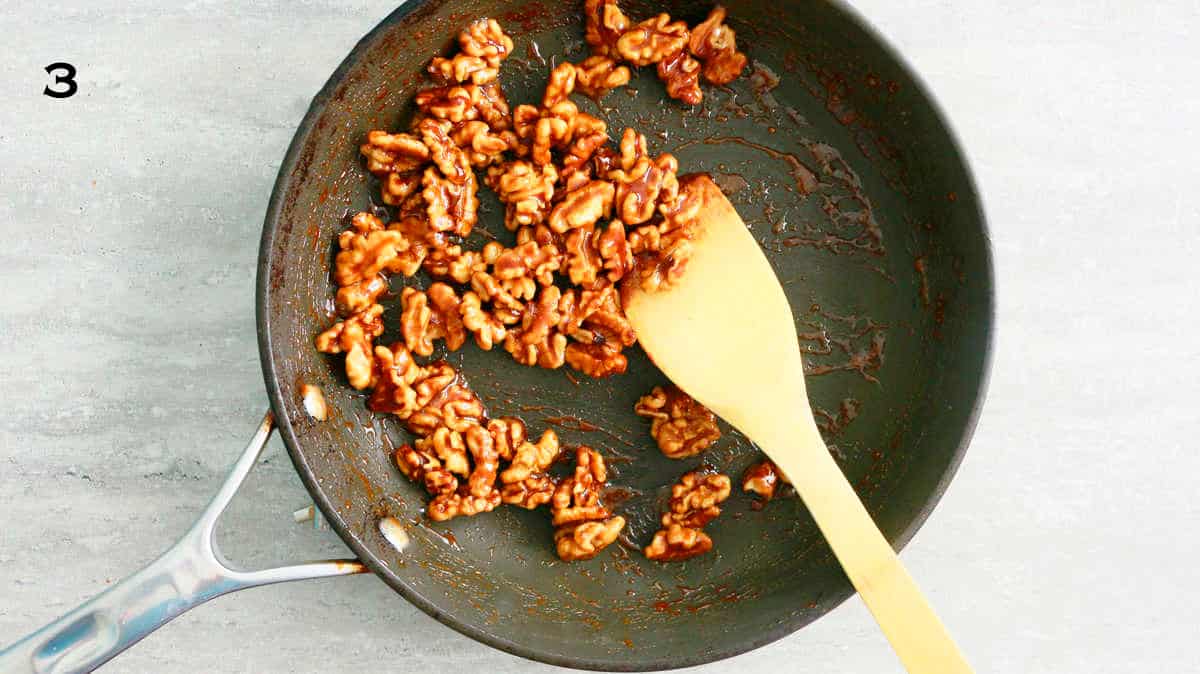 caramel walnuts cooking in a black skillet.