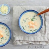 shrimp soup in blue bowls with spoons.