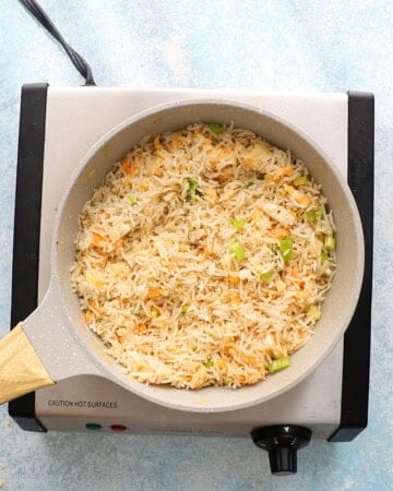 cooked garlic fried rice in a white skillet.