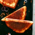 1 diagonally cut sandwich on a black board.