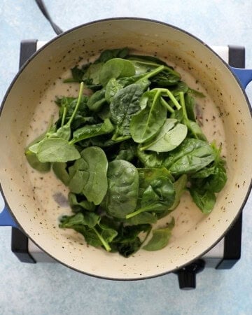 green spinach leaves in a white pot.