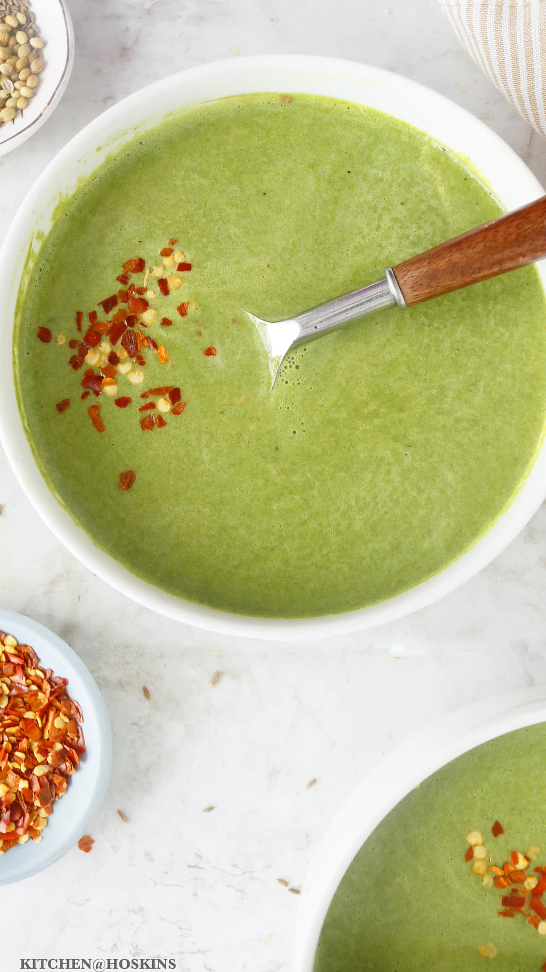 Cream of spinach soup topped with red pepper flakes. 
