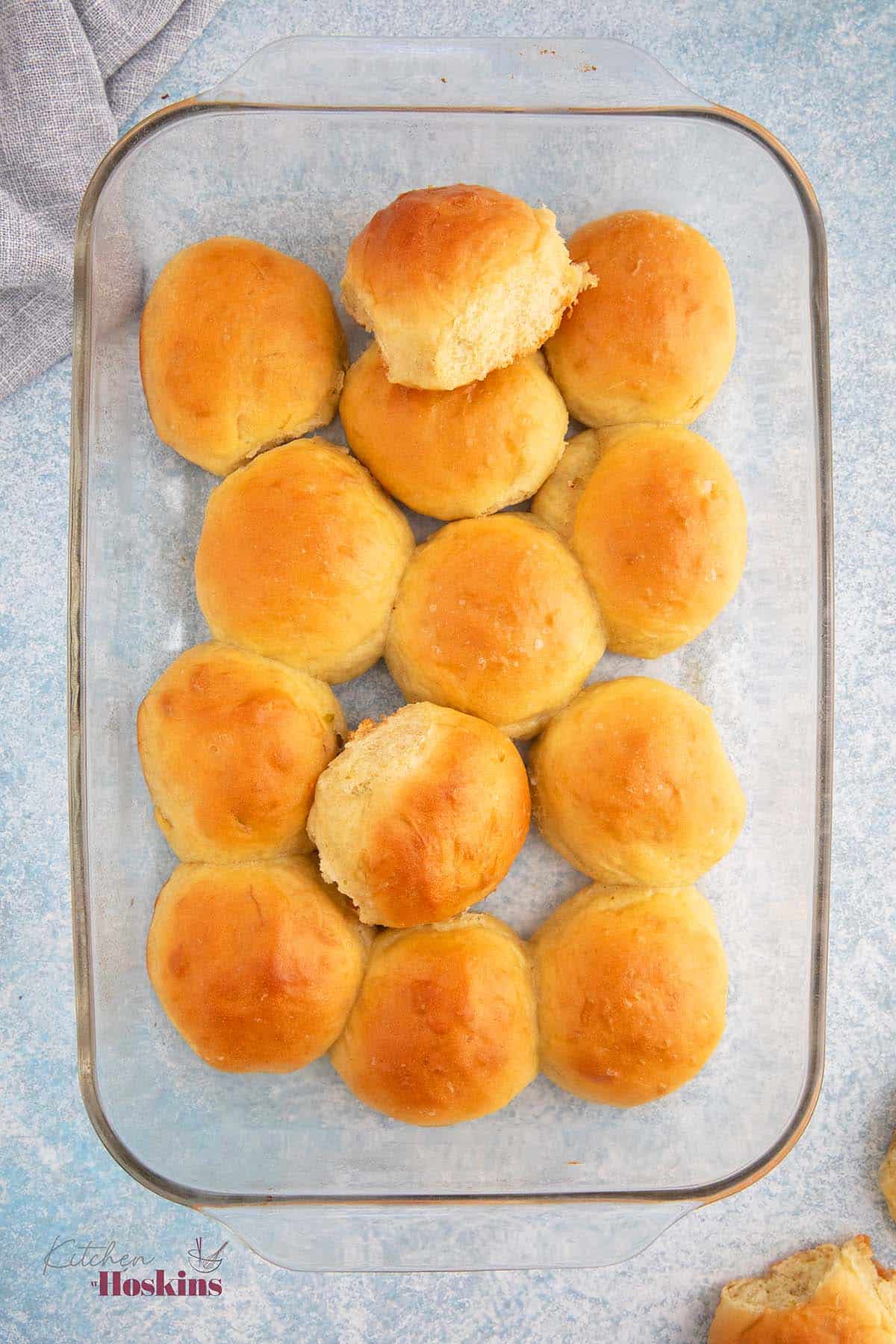  a rectangular glass dish with baked no knead dinner rolls. 