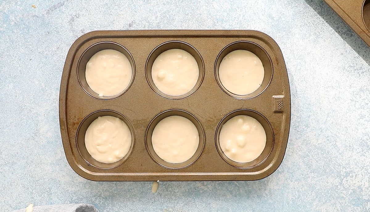 one 6 cup muffin pan with filled with pancake batter.
