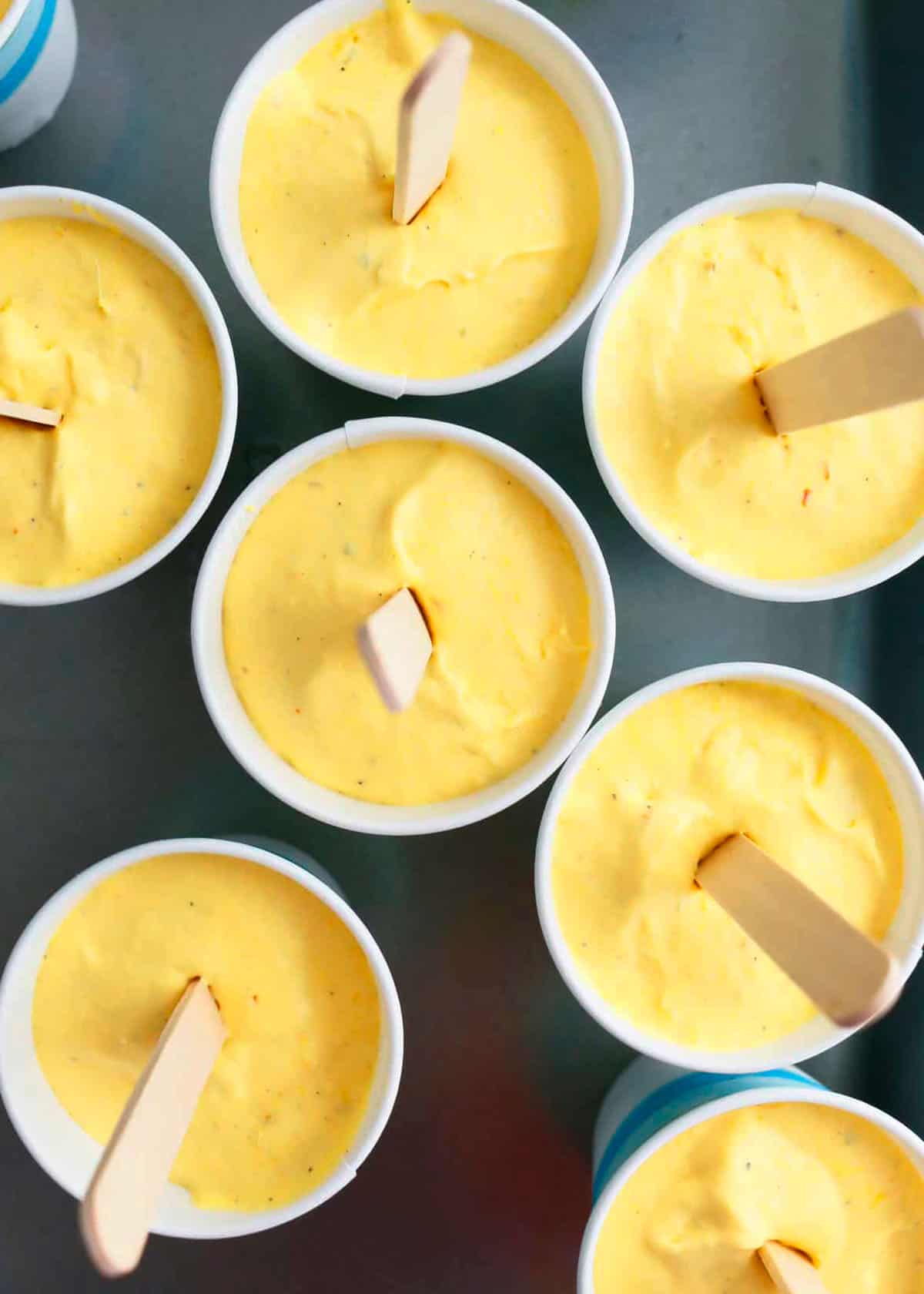 9 mango popsicles in a black tray.