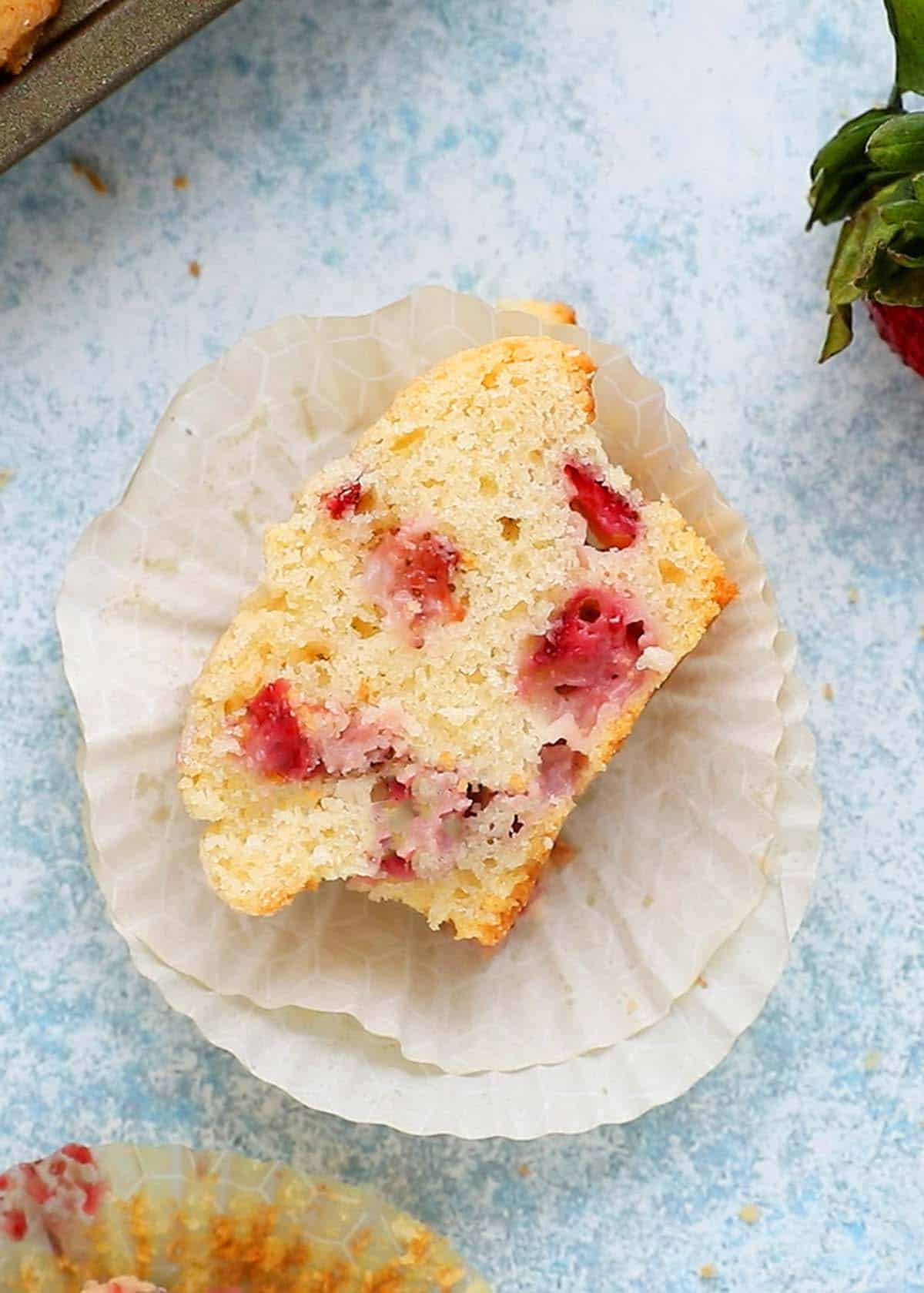 one half cut strawberry muffin placed on paper liners.