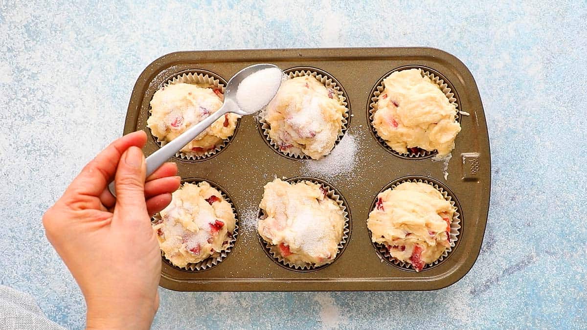 a 6 cup muffin pan filled with strawberry muffin batter.