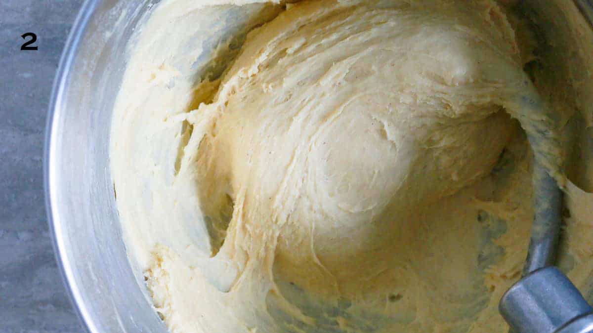 donut dough in a stainless steel bowl of stand mixer.