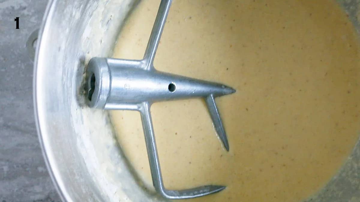 donut dough in a stainless steel bowl of stand mixer along with flat beater.