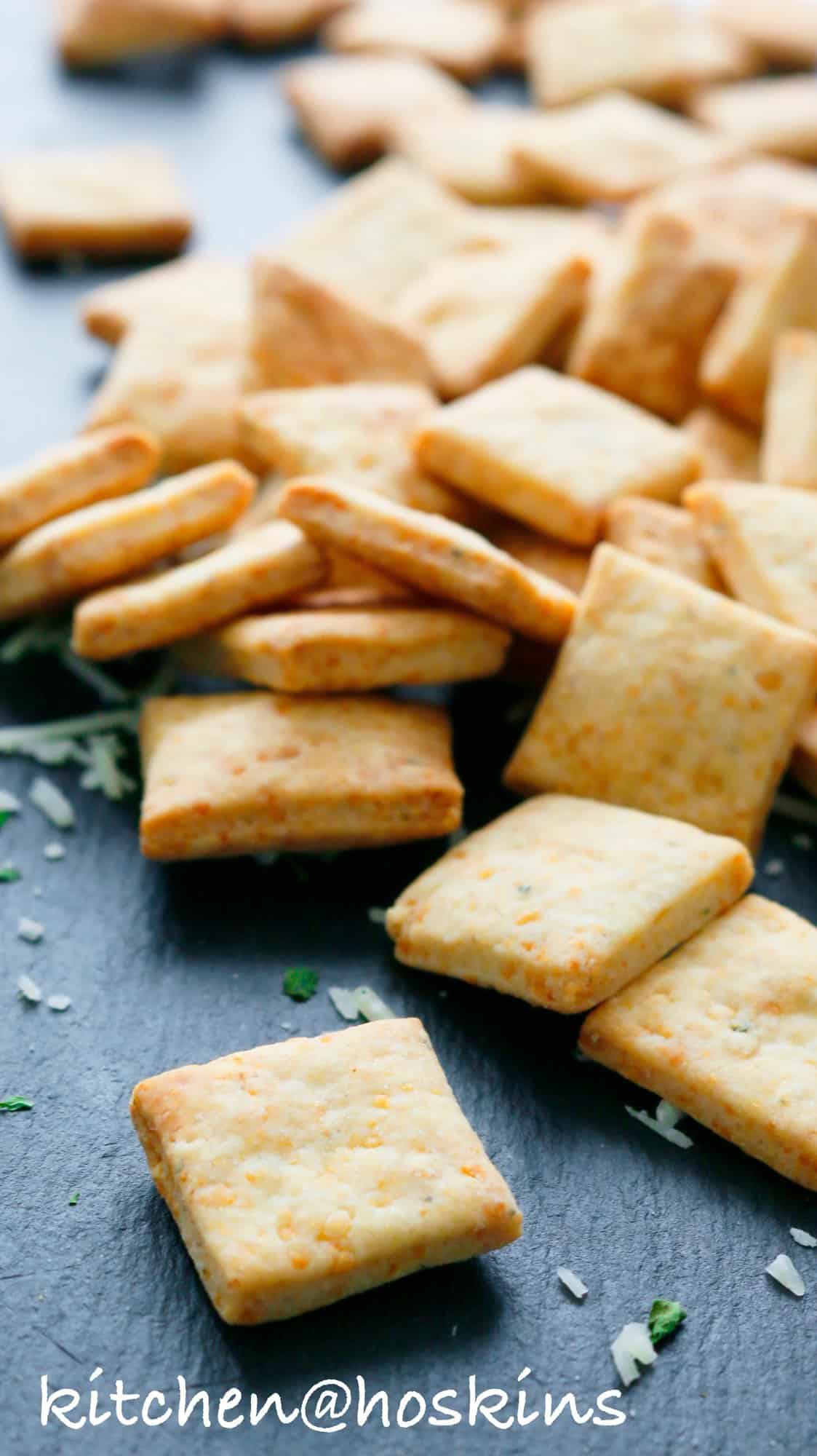 homemade crackers with parmesan cheese on a black board. 
