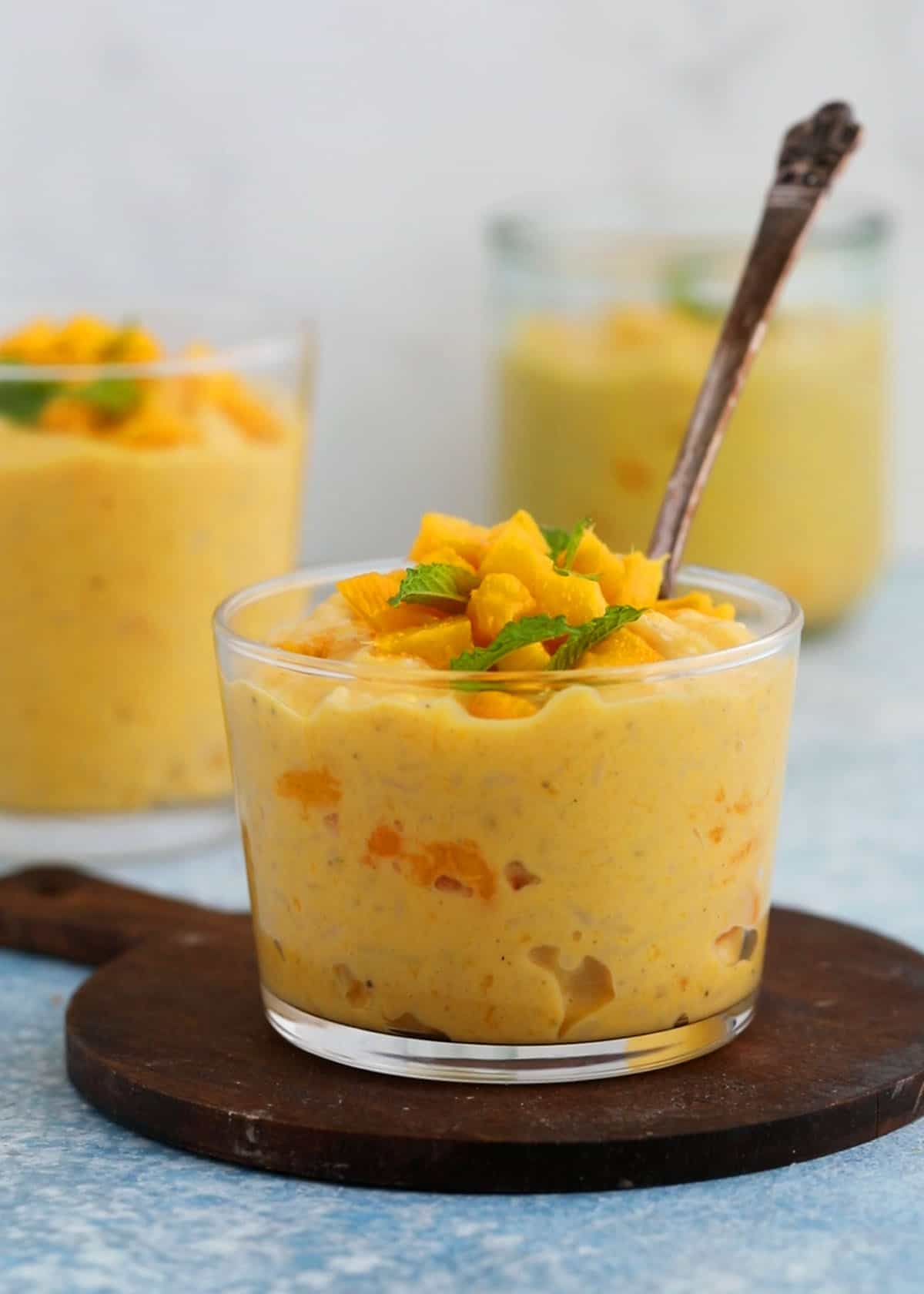 yellow colored mango pudding in a glass jar.