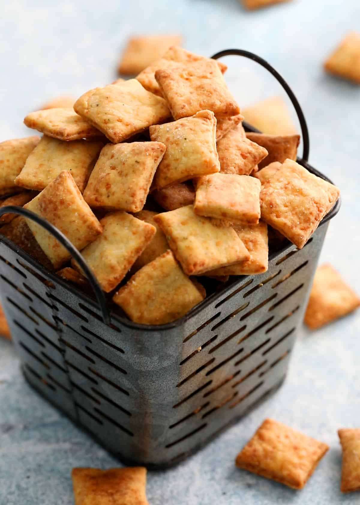 square crackers piled high in a metal basket.