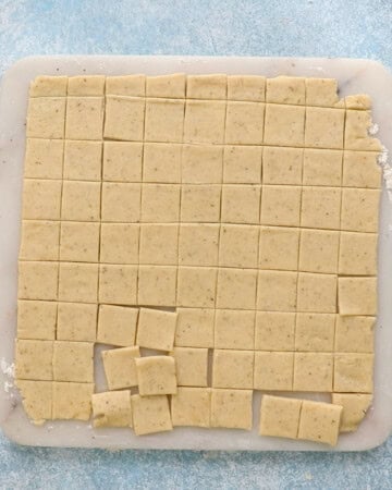 cut square shaped crackers placed on a white marble.