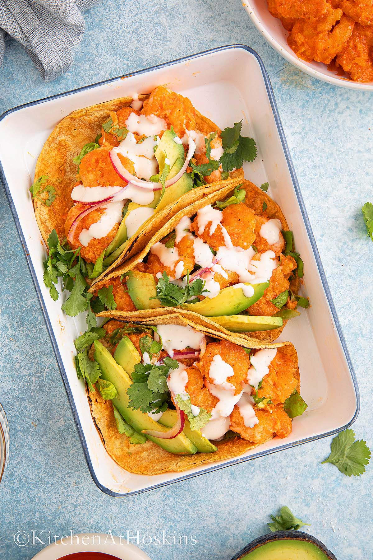white rectangle tray filled with 3 shrimp tacos.