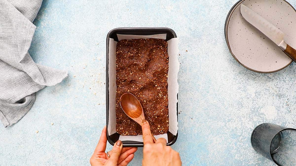 shaping date nut mixture in a loaf pan.