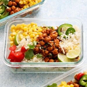 spicy chickpeas, rice and toppings in a rectangular glass bowl.